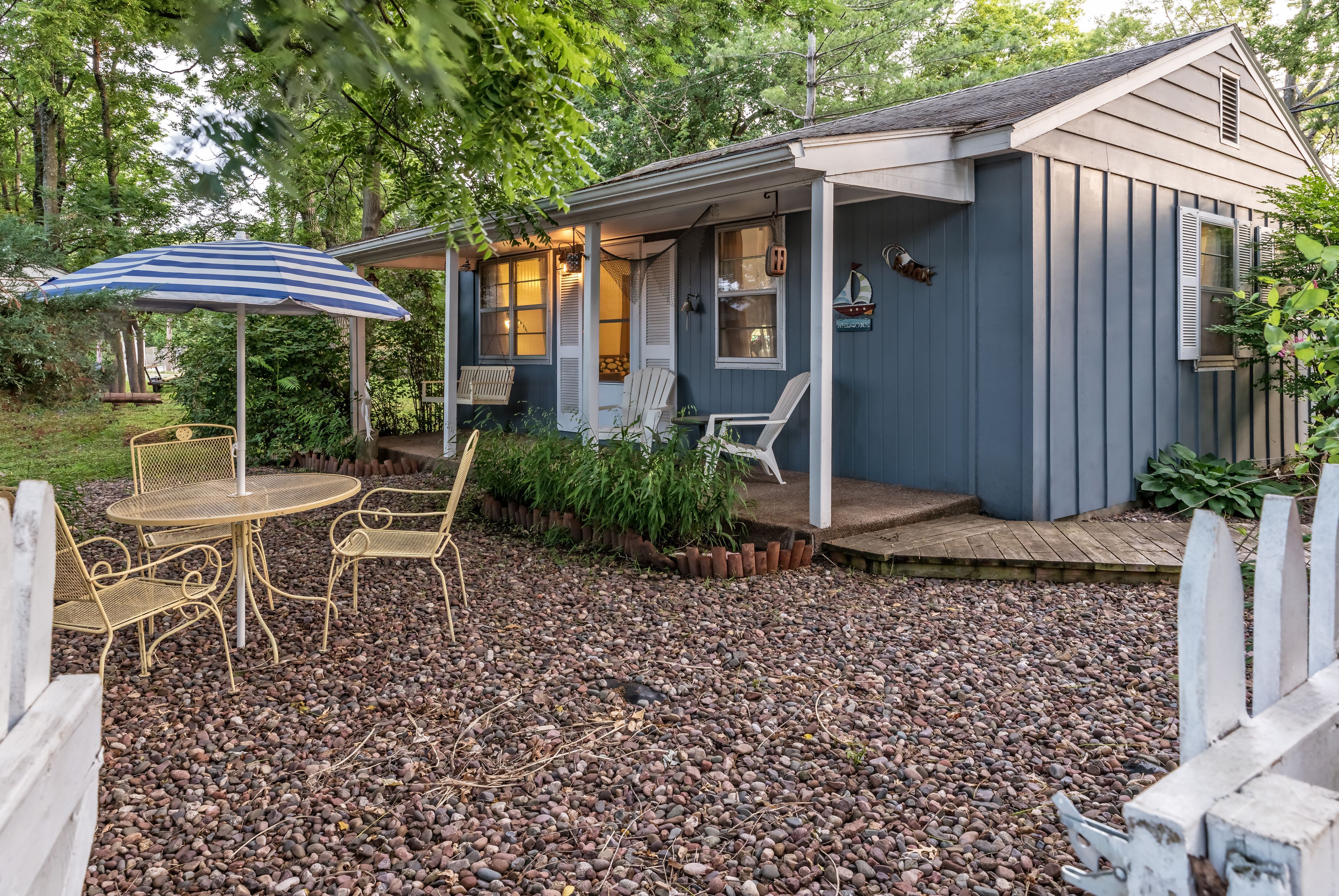 A house with a porch, outdoor seating, and a covered patio area.