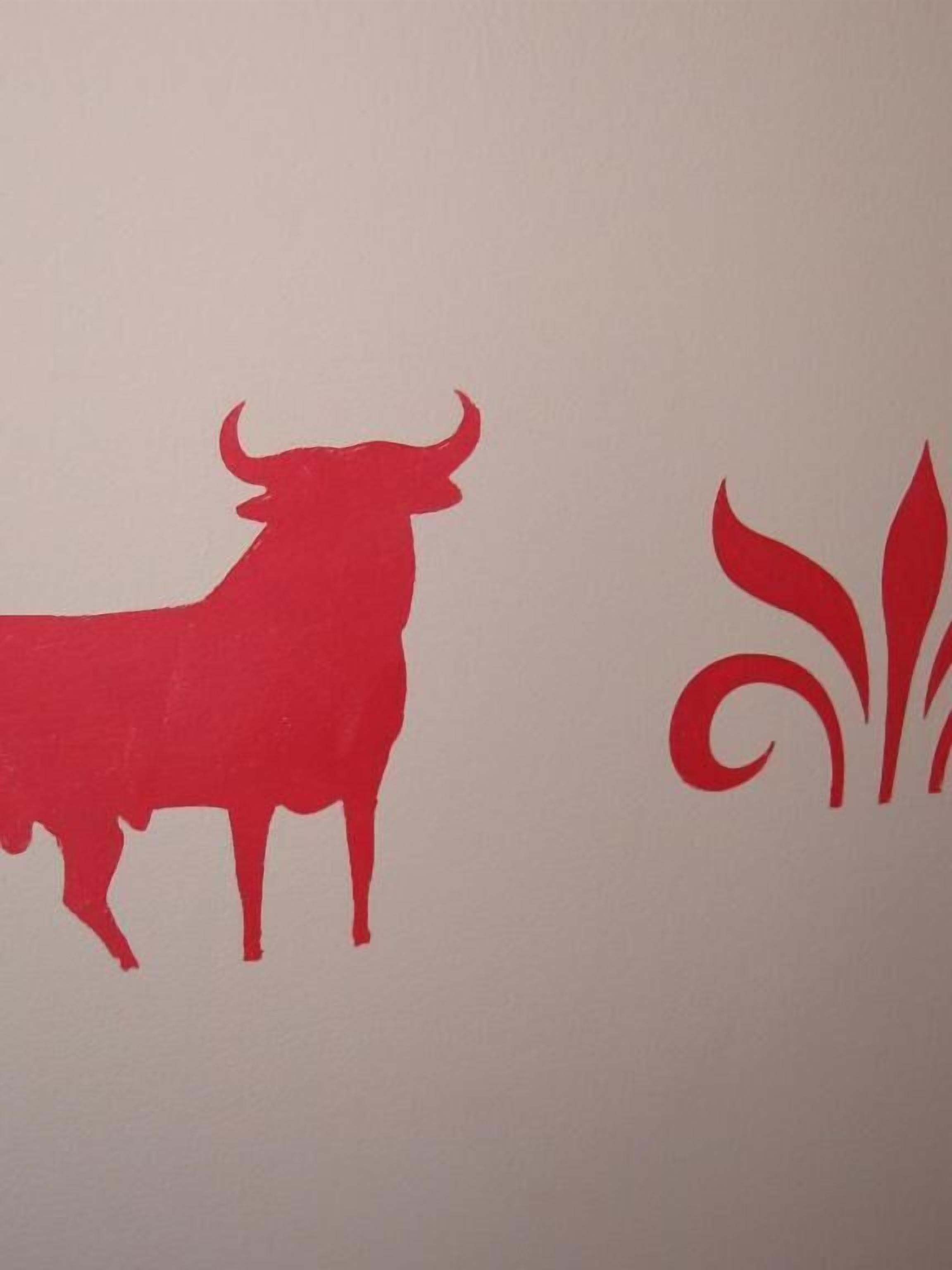 Una pared con un toro y un diseño floral.