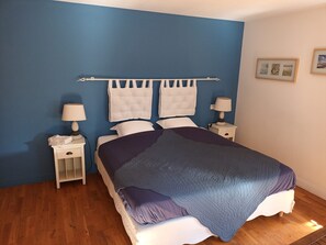 A bedroom with a bed, two bedside tables, a nightstand, and a headboard with a towel rack. - Chambres d'hôtes L'Airial (Liposthey)