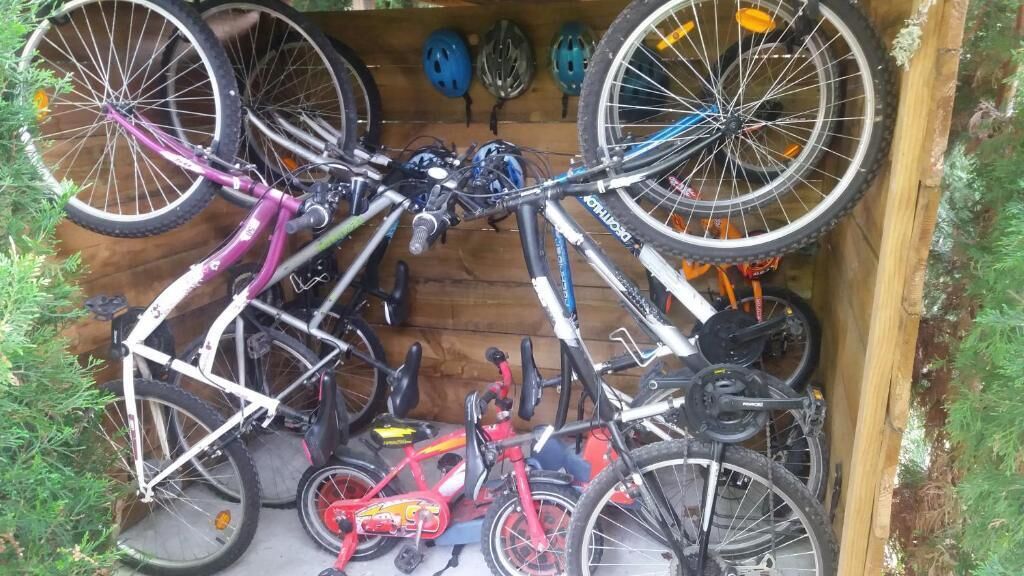 A wooden structure with bicycles and helmets.