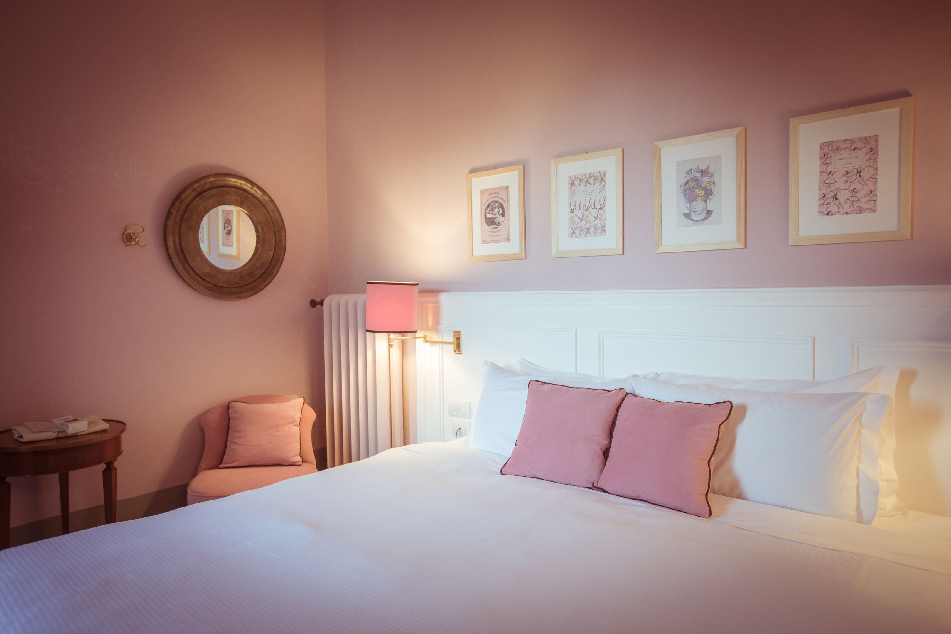 Ein ordentlich eingerichtetes Schlafzimmer mit einem großen Bett, einem Nachttisch, einem Sessel und einem Wandspiegel.