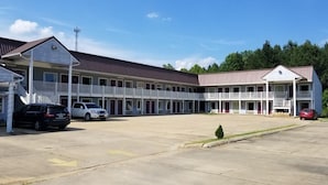A motel with a central courtyard, multiple rooms, and a parking area.