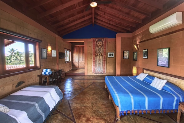 A room with two beds, a wooden ceiling, and a view of palm trees outside. - Hotel Casa San Pancho (San Francisco)