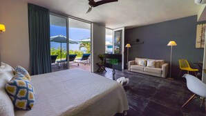 A spacious bedroom with a large bed, a ceiling fan, and a view of the outdoors. - Suites at Sapphire Ocean Club (Puerto Vallarta)