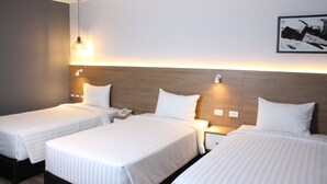 A hotel room with two single beds, a wooden headboard, bedside lamps, a telephone, and a framed picture on the wall. - Habitat Hotel (Lima)