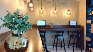 A modern hotel lobby with a wooden reception desk, two computer monitors, and a large mirror. - Habitat Hotel (Lima)