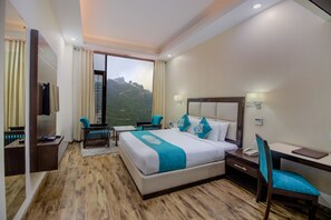 A hotel room with a large bed, a desk, a chair, and a TV. - Snow Valley Resorts (Shimla)