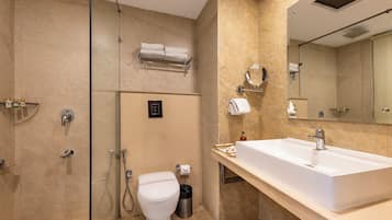 Une salle de bain moderne avec un grand lavabo, des toilettes, une douche et un miroir.