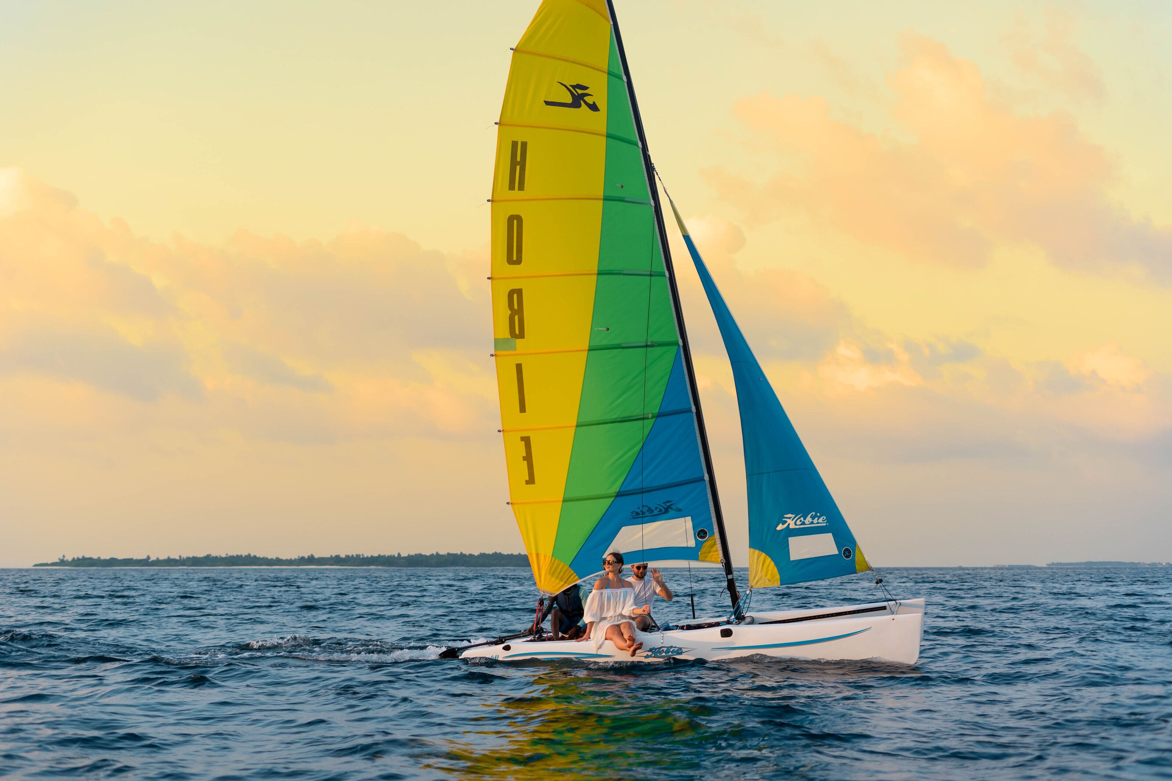 A sailboat with a colorful sail on the water.
