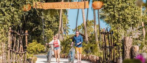 A sign for 'Wellness Village' with a rustic wooden archway and a logo.