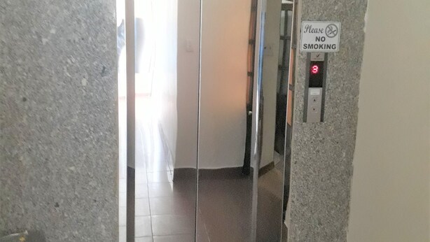 An elevator with a 'No Smoking' sign, a digital display, and a trash bin beside it. - Blue Sea 2 Hotel (Bac Nha Trang)