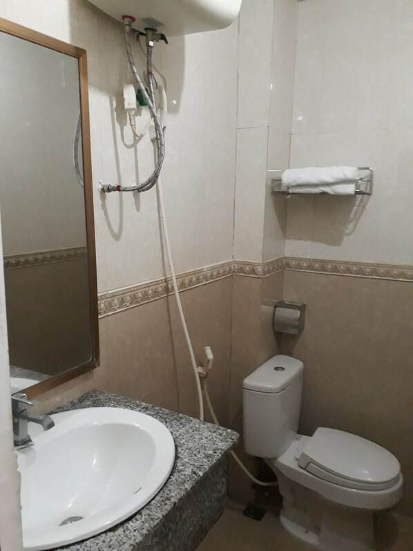 A bathroom with a sink, toilet, and a towel rack.