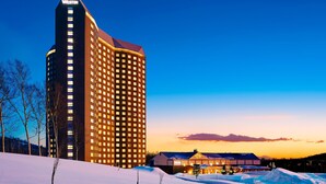A tall hotel with a prominent 'WESTIN' sign, surrounded by snow-covered landscape and a clear sky. - The Westin Rusutsu Resort (Rusutsu)