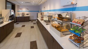 A breakfast area with a self-serve station, a microwave, and a display of food options. - Holiday Inn Express & Suites Alpena - Downtown by IHG (Alpena)