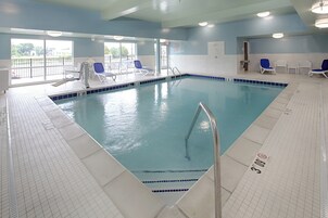 Una piscina techada, sillones reclinables de piscina