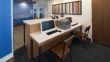 A modern office space with a desk, computer, printer, and a telephone.
