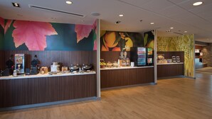 A modern breakfast area with a waffle maker, coffee machine, and fruit display. - Fairfield Inn & Suites Houma Southeast (Houma)
