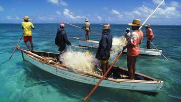 A group of people in a small boat on clear blue water.