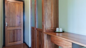 A hallway with wooden flooring and a built-in wooden cabinet with a shelf. - Lakaz Safran (La Digue)