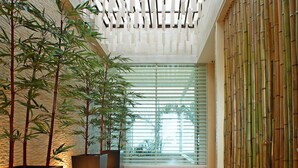 A corridor with bamboo plants, wooden flooring, and a ceiling with a grid-like pattern. - Changhua KuiKuan Boutique Motel (Changhua)