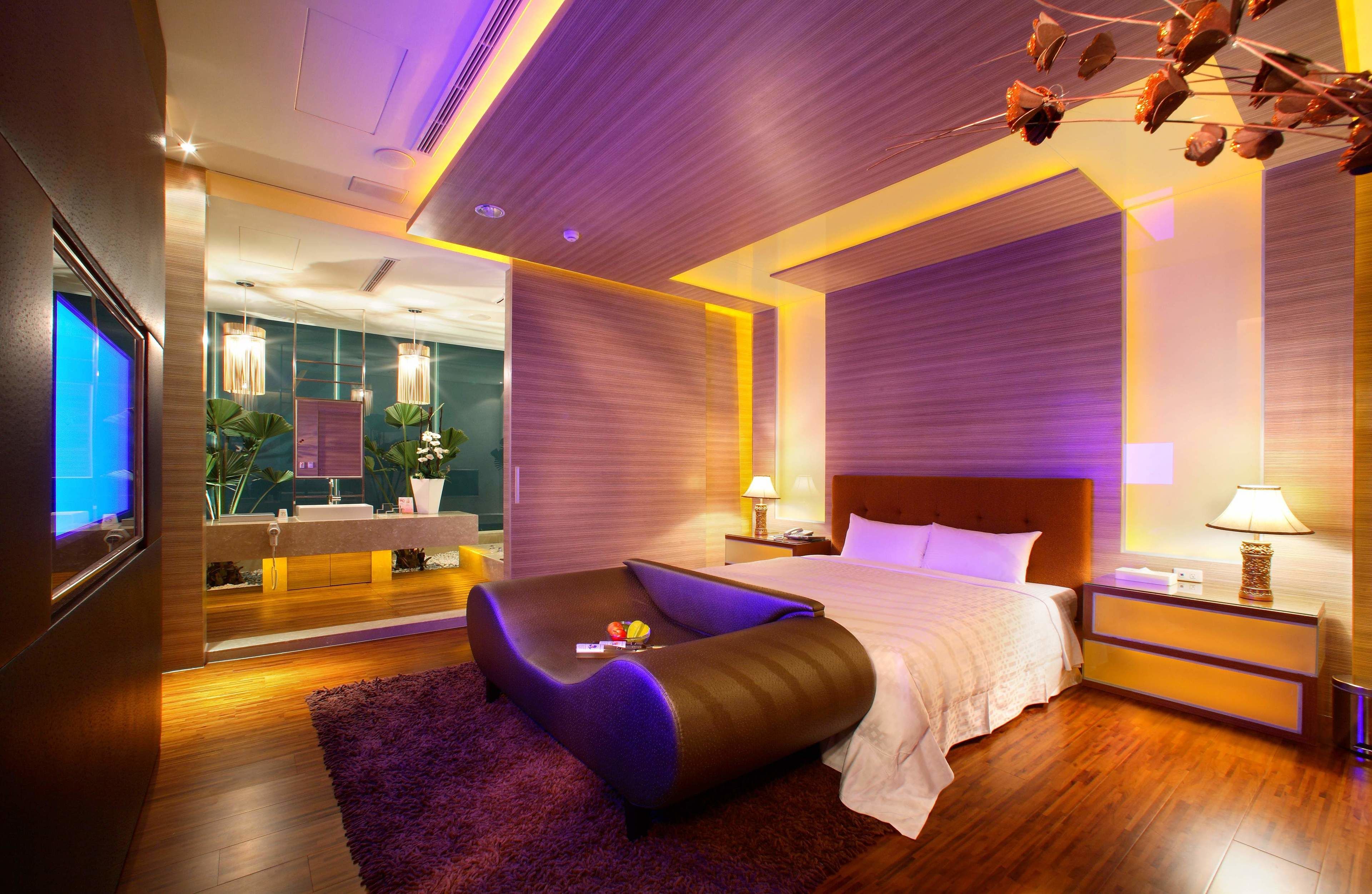 Une chambre d’hôtel moderne dotée d’un grand lit, d’un coin salon et d’une télévision.
