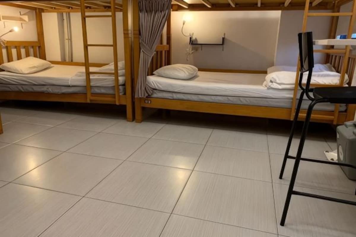 Un dormitorio con literas, un escritorio y una silla.