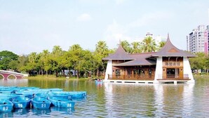A traditional pavilion in the middle of a lake surrounded by blue boats, with a bridge in the background. - Backpacker 41 hostel - Taichung (Taichung)