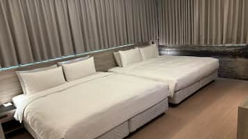 A modern hotel room with two beds, a wooden headboard, and a view of a stone wall.