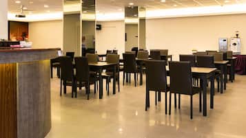 A conference room with a curved reception desk, multiple tables and chairs, and a water dispenser.
