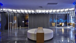 A modern lobby with a central seating area, a reception desk, and a wall with vertical light fixtures. - Yuhao Hotel Hsinchu (Hsinchu)