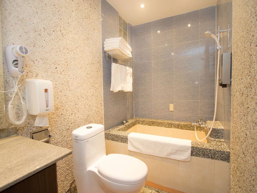 A bathroom with a toilet, a sink, a shower, and a towel rack.