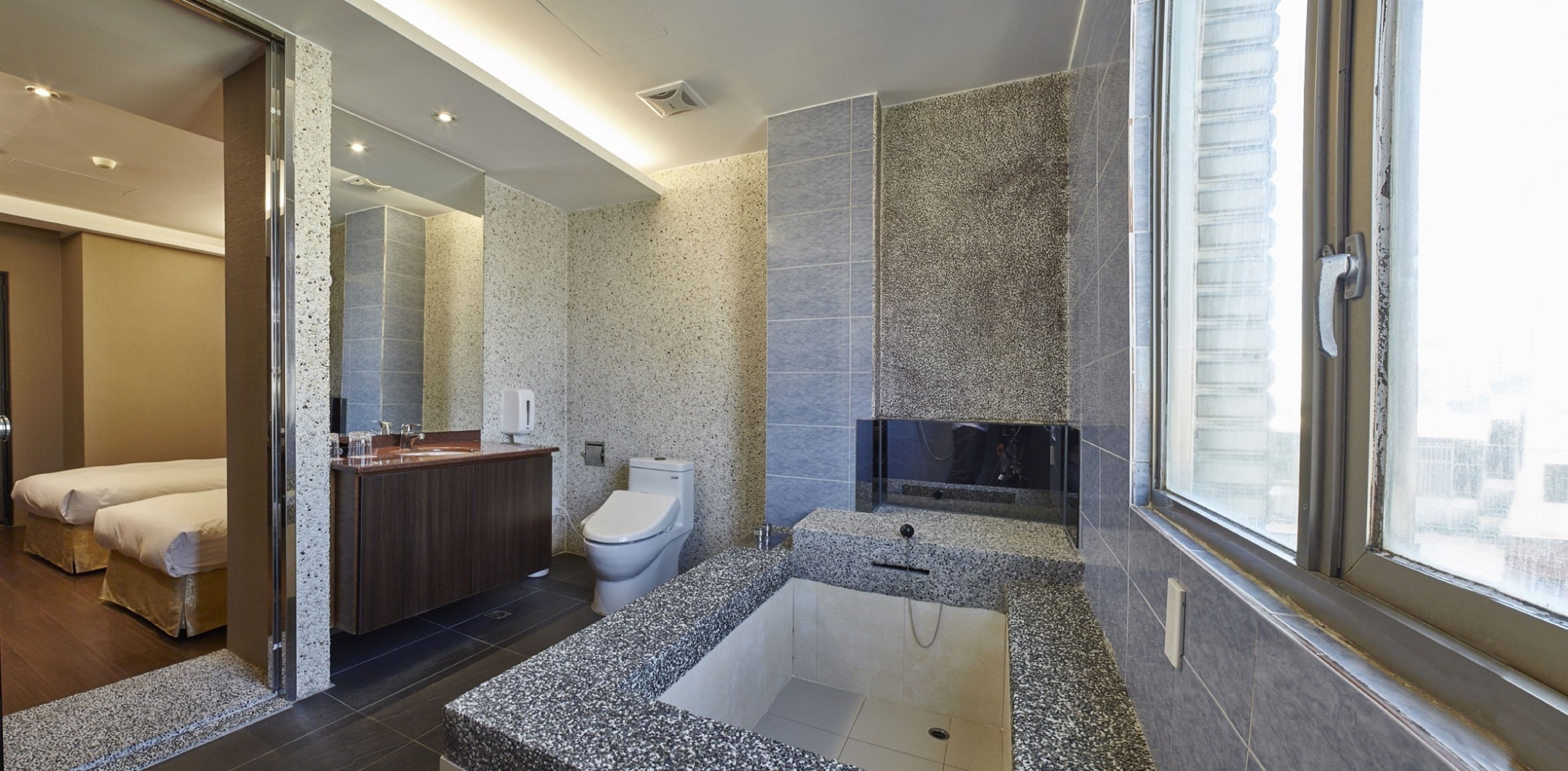Un baño moderno con una bañera grande, un inodoro separado y una zona de ducha.