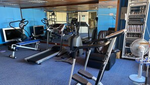 A gym with treadmills, elliptical machines, and weight equipment.