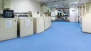 A laboratory with beige cabinets, a blue floor, and a door leading to another room.