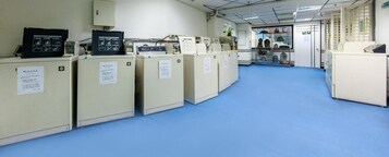 Un laboratorio con armarios color beige, piso azul y una puerta que da a otra habitación.