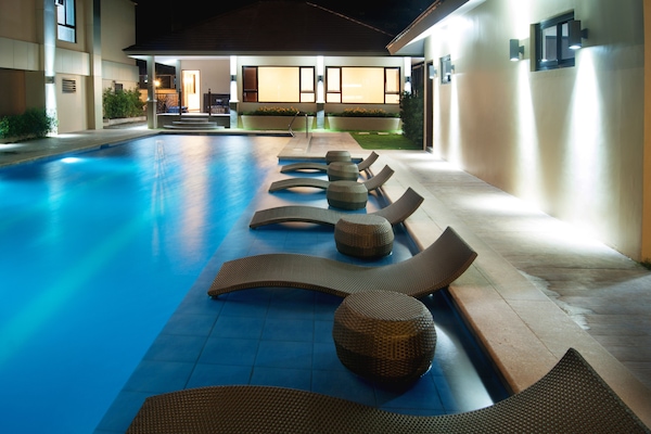 Una piscina al aire libre, tumbonas