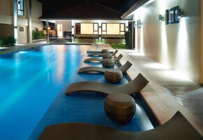 Una piscina al aire libre, tumbonas