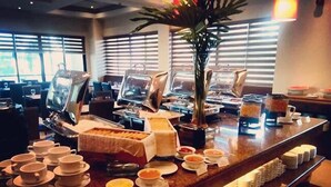 Montaje tipo bufé con diferentes opciones de comida y una estación de café.