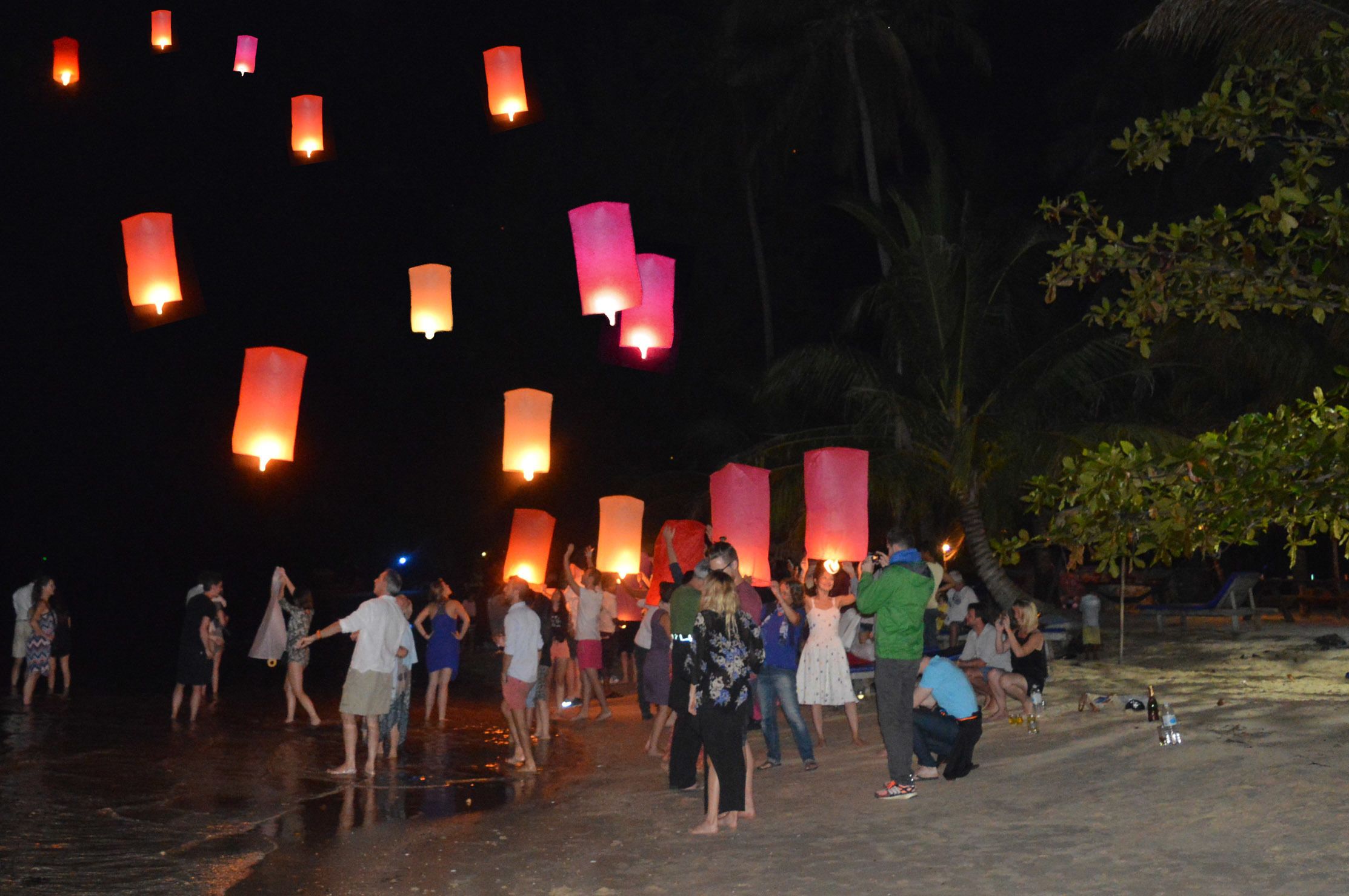 A group of people participating in a lantern release event at night.