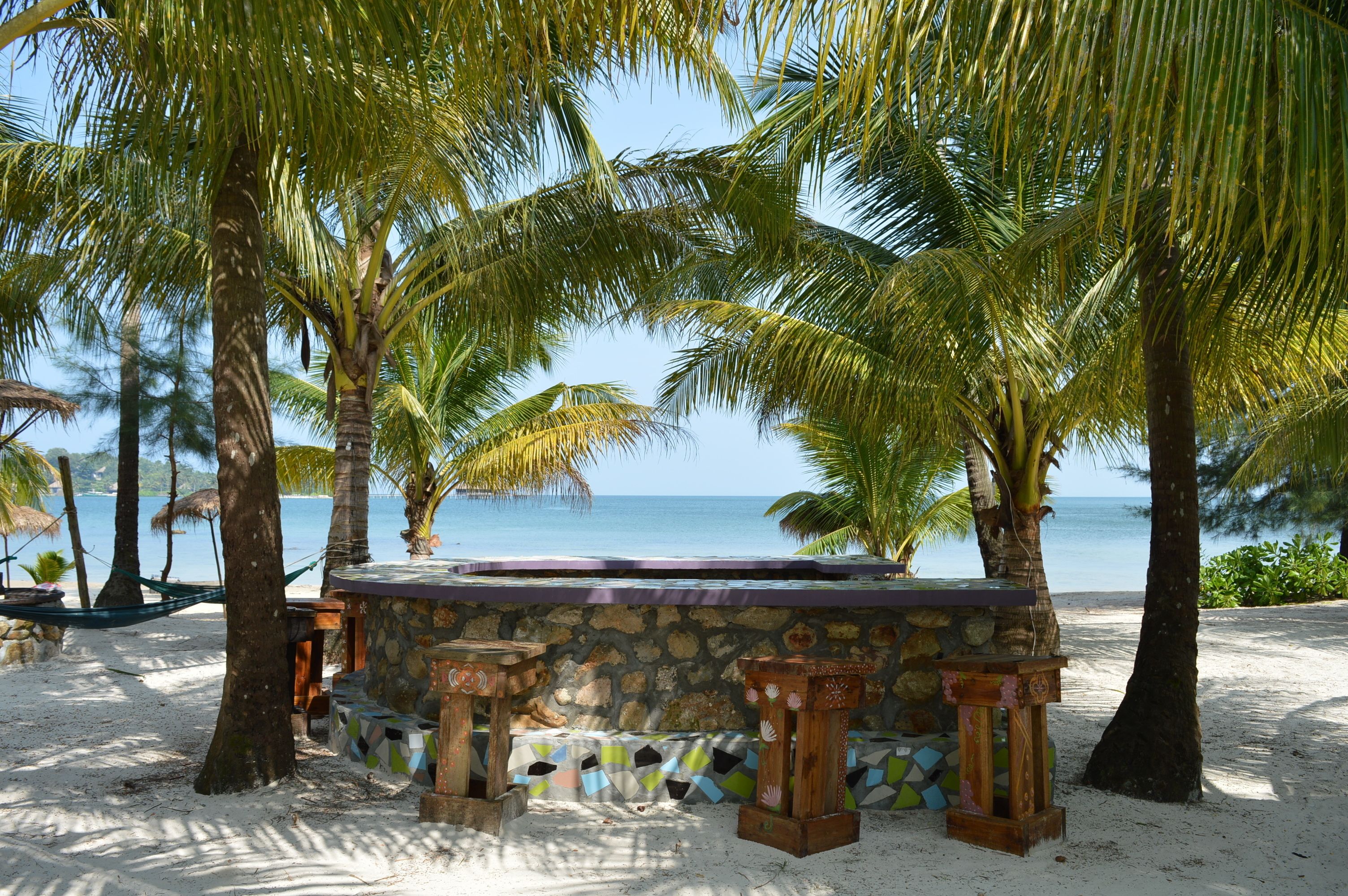 På stranden, solsenger, parasoller og sandvolleyball