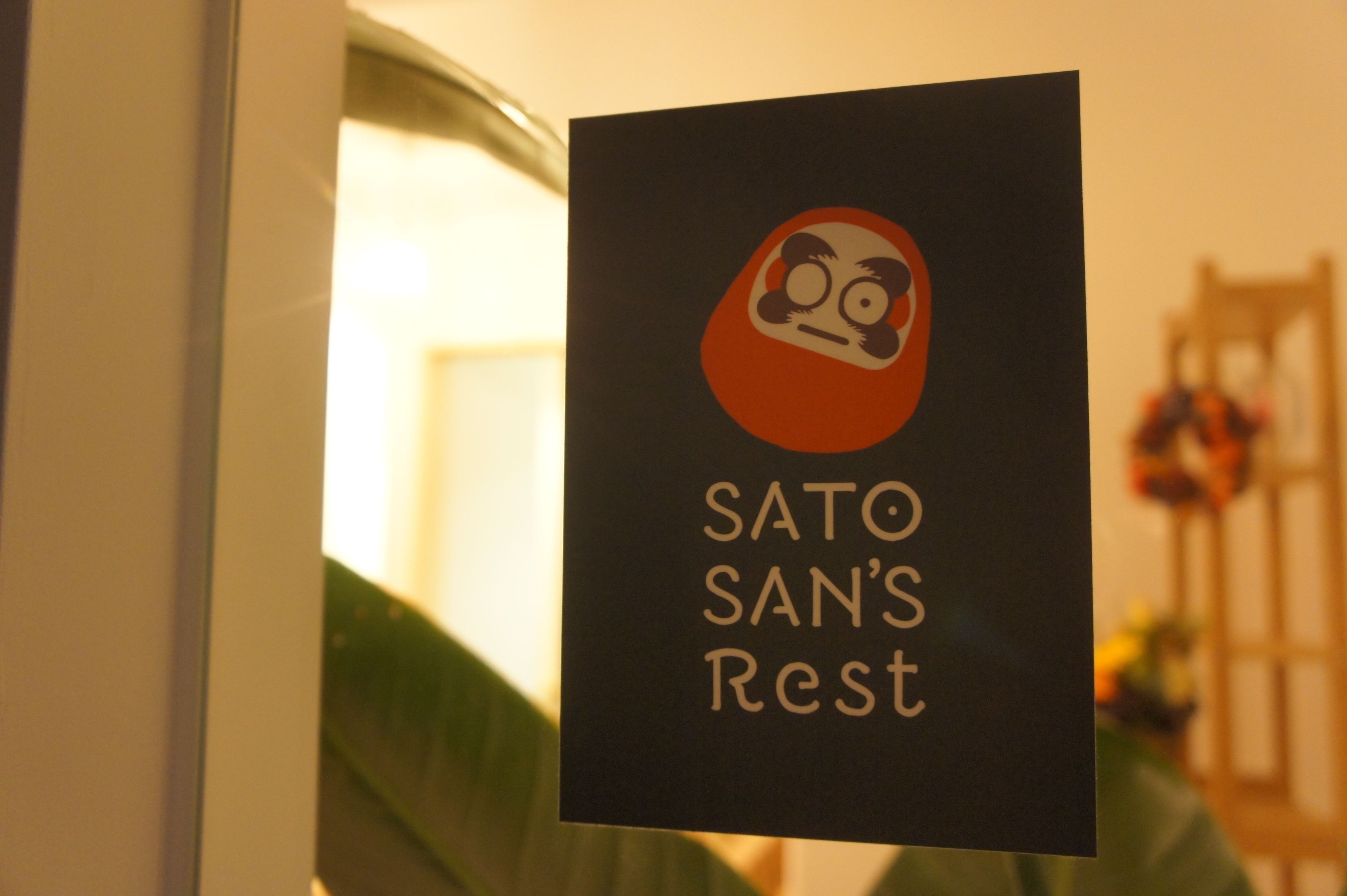 A sign for SATO SAN'S Rest with a stylized bear logo.