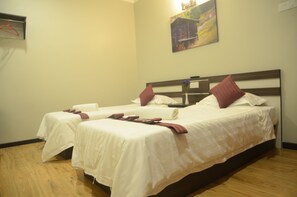 A hotel room with two single beds, each with white linens and red pillows. There is a painting on the wall above the beds. - Zermatt Hotel (Tanah Rata)