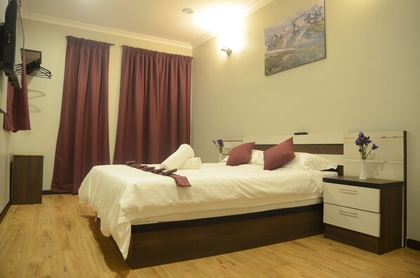 Habitación Deluxe, 1 cama Queen size | Escritorio, tabla de planchar con plancha, wifi gratis y ropa de cama 