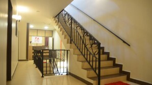 A staircase with a black railing leading to a landing. - Zermatt Hotel (Tanah Rata)