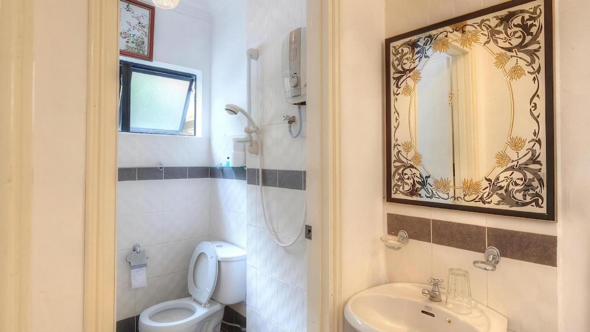 Une salle de bain avec des toilettes, une douche et un lavabo.