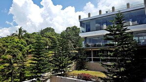 A modern building with a glass facade, surrounded by lush greenery and a well-maintained garden. - Splash Suites Hotel Tagaytay (Tagaytay)