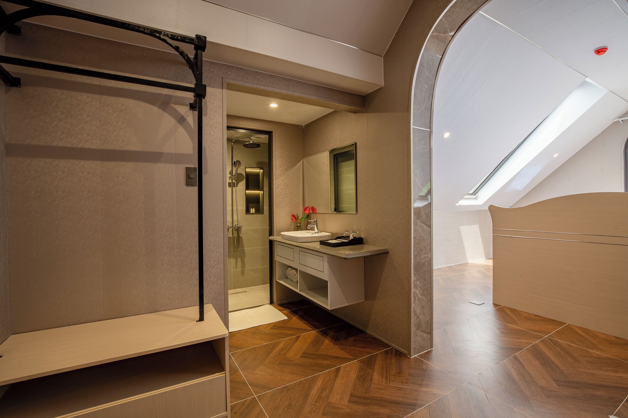 Un baño moderno con ducha, tocador y tragaluz.