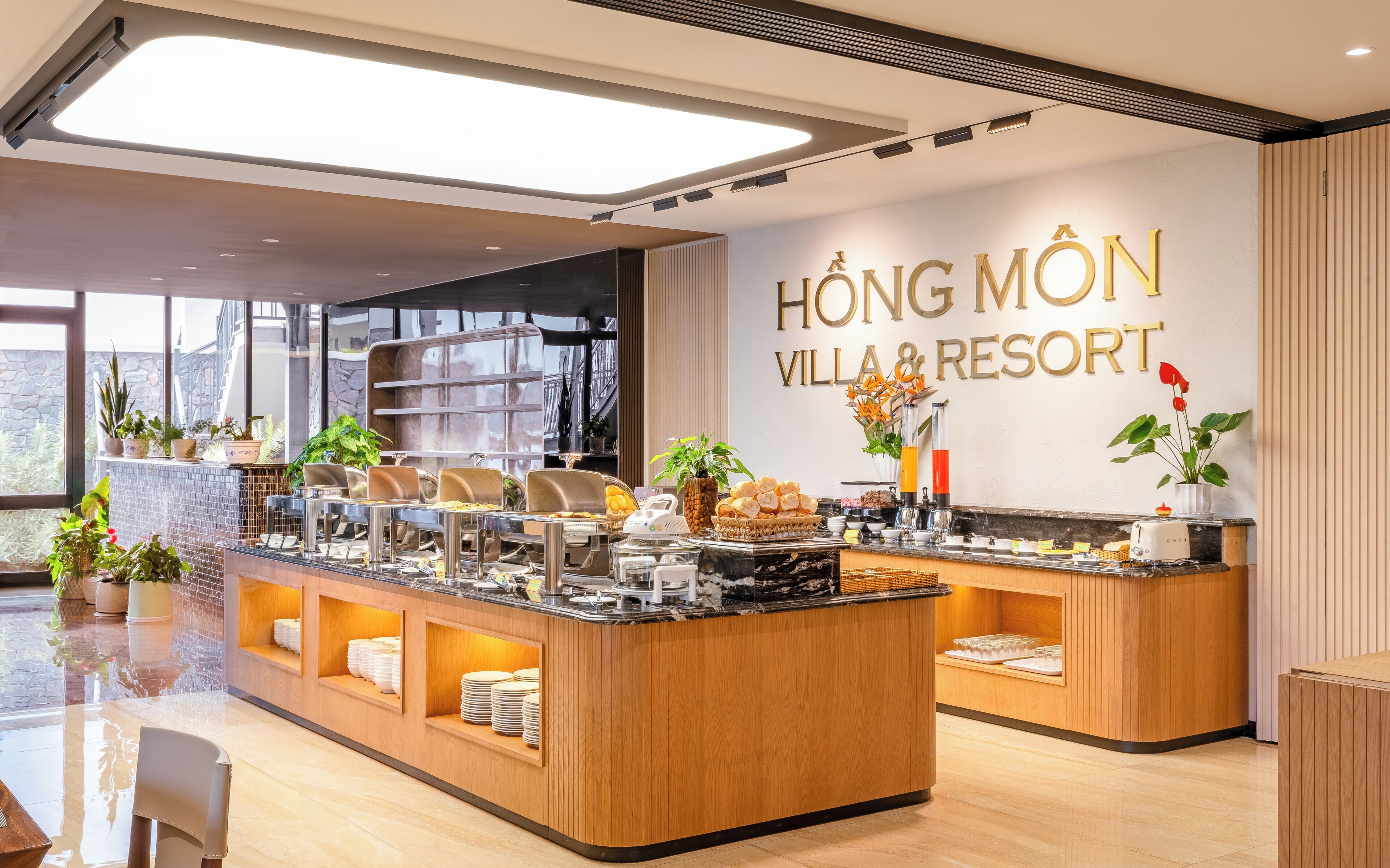 A modern breakfast buffet area with a sign for HONG MON VILLAS & RESORT.
