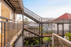 A multi-level outdoor balcony with metal railings, a stone wall, and a view of a residential area. - Hong Mon Resort Da Lat (Xuan Huong - Da Lat)