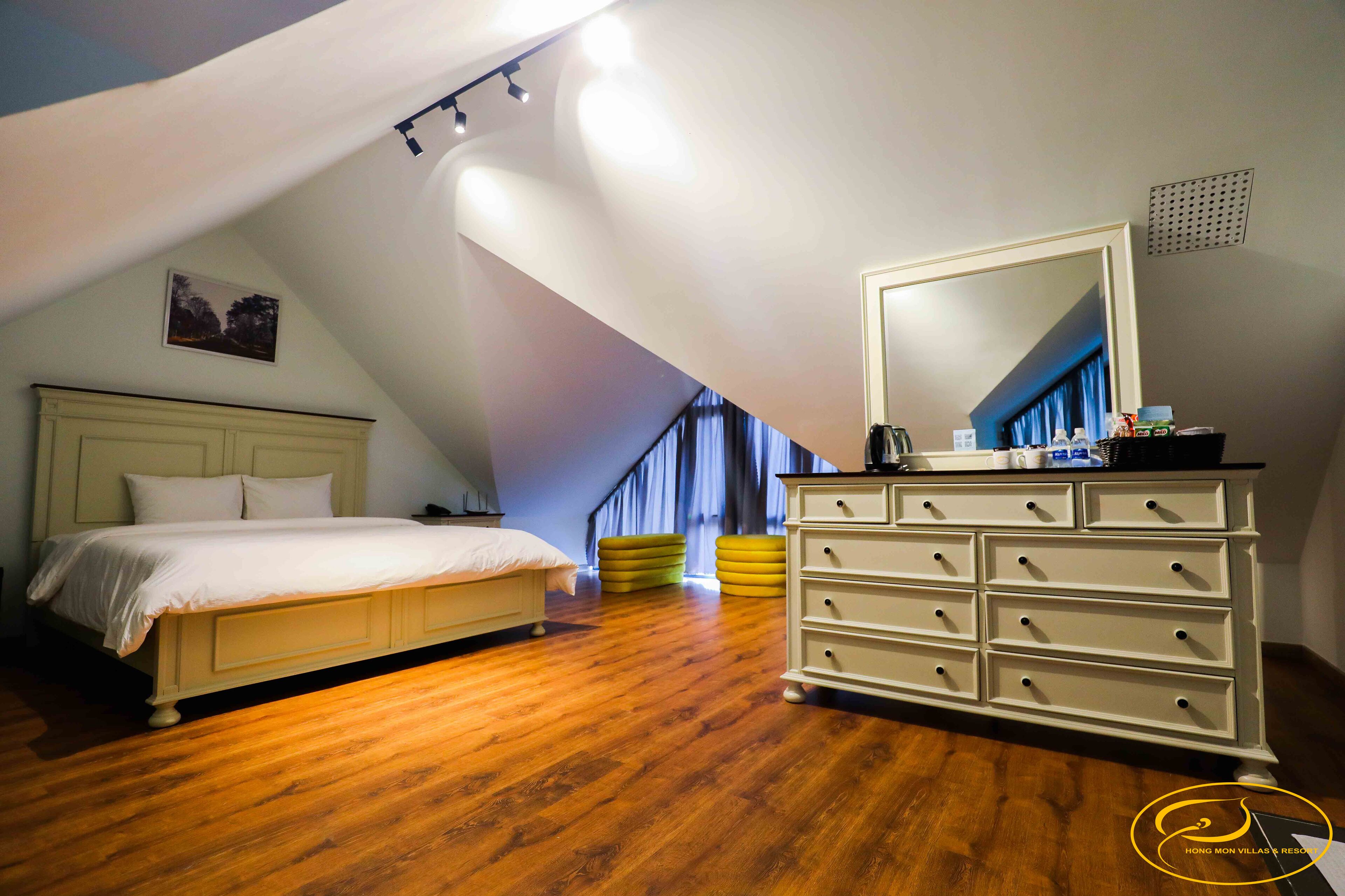 A bedroom with a bed, a dresser, and a large mirror.